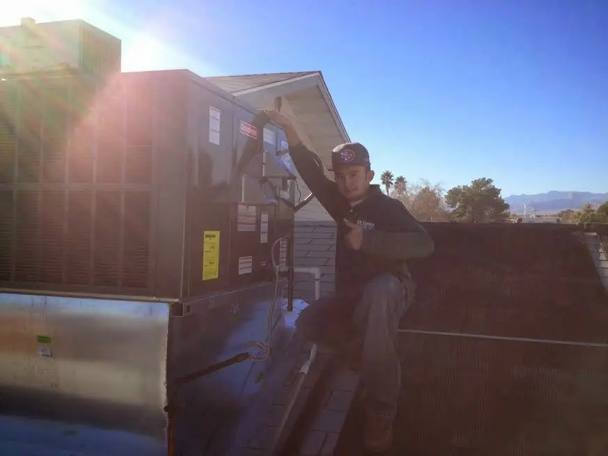 HVAC technician performing AC Tune-Up on a rooftop unit in Brooklyn Park